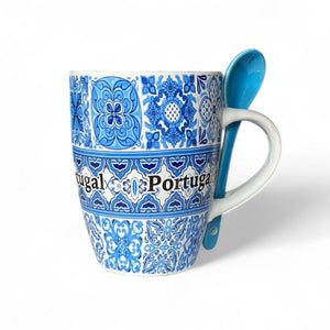 A blue and white ceramic mug with a striped tile design and the word 'Portugal' written on it, accompanied by a matching blue spoon, displayed against a white background.
