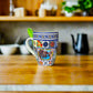 A close-up of a decorative Algarve-themed mug with intricate tile designs. The mug’s 'ALGARVE' label is prominently displayed, making this item a perfect souvenir from Portugal's scenic southern region.