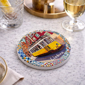 Angled view of Lisbon souvenir coaster showing tram illustration and colorful azulejos pattern