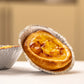 Close-up of Lisbon pastel de nata with golden custard filling in traditional aluminum mold