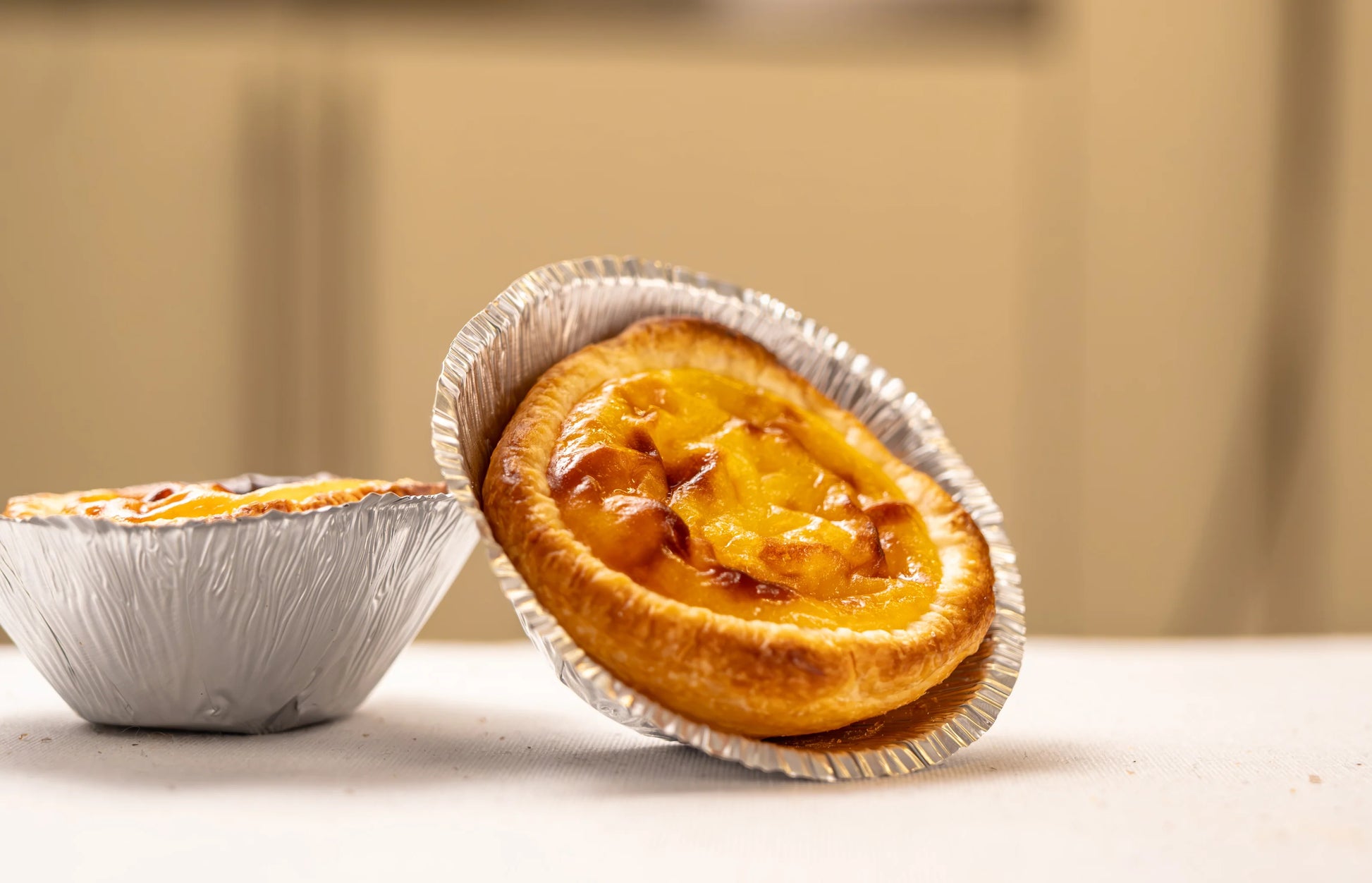 Close-up of Lisbon pastel de nata with golden custard filling in traditional aluminum mold