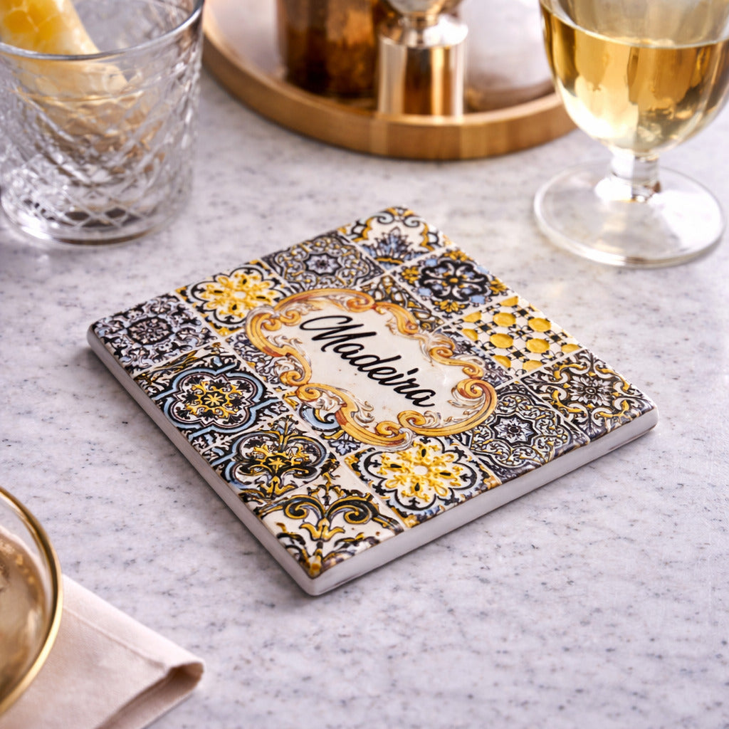 Madeira souvenir square coaster with azulejos design placed on table with drinks in elegant setting