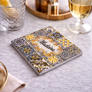 Madeira souvenir square coaster with azulejos design placed on table with drinks in elegant setting