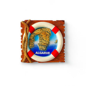 A colorful fridge magnet featuring a lifeguard ring with a cliff rock coastal design, predominantly in shades of blue and brown, mounted on a white background.