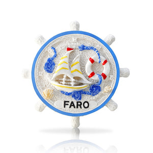 A decorative resin magnet designed as a ship's wheel with a sailboat, marine ornaments, and the name 'Faro' displayed at the bottom.