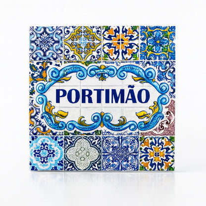 A square Portuguese ceramic tile with intricate blue, yellow, and white patterns. The center features the name "PORTIMÃO" in bold blue letters, surrounded by floral and geometric designs. The tile, reflecting the traditional Azulejo style of Portugal's Algarve region, is a beautiful piece of craftsmanship.