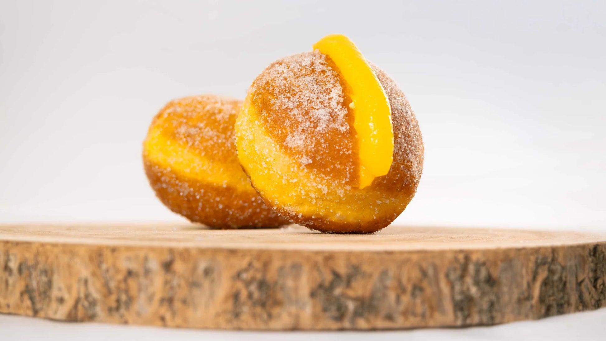 Close-up of traditional Portugal Bola de Berlim filled with egg cream and coated in sugar