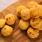 Close-up of Portugal cheese balls pão de queijo on wooden board with golden baked texture