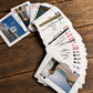 Portugal-themed playing cards on a rustic wooden surface, highlighting Portuguese monuments, beaches, regions, and iconic travel destinations.
