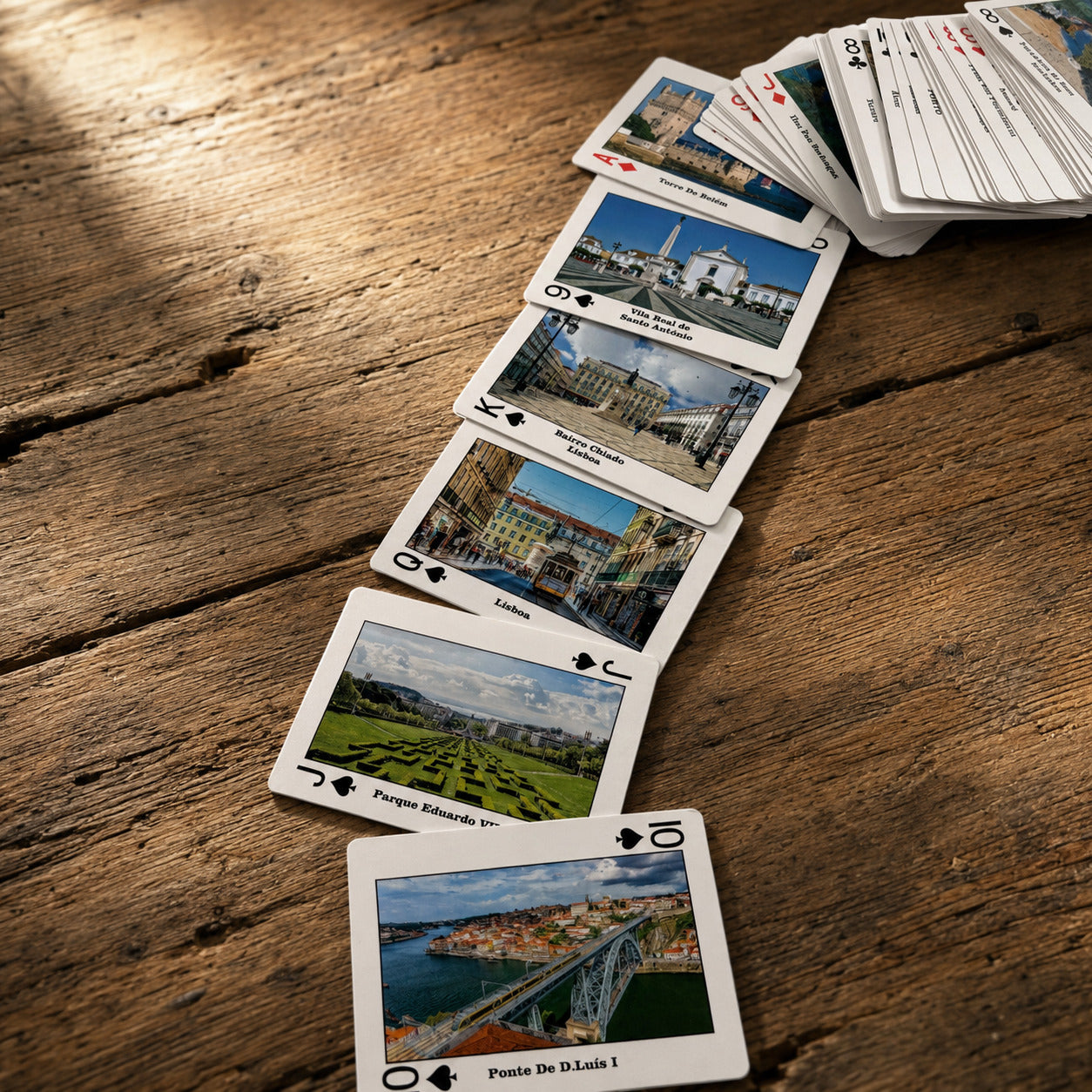 Portuguese souvenir card deck arranged in a long display, with each playing card featuring a different city, region, monument, or cultural attraction in Portugal.