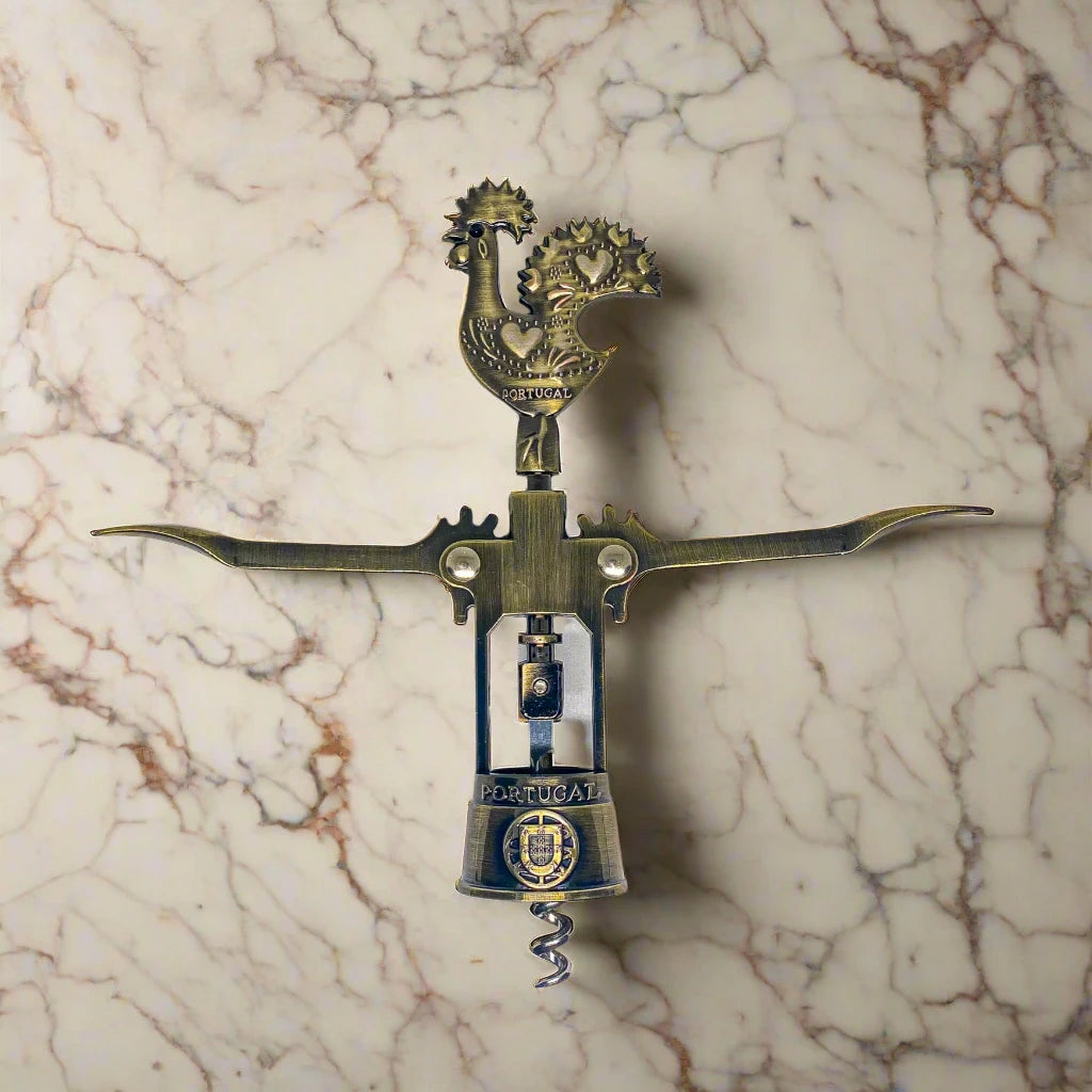 This intricately detailed bronze corkscrew features a handle shaped like the Barcelos Rooster, a beloved Portuguese symbol. The handle incorporates a heart design, and "Portugal" is prominently displayed on the midsection. The corkscrew is complete with two levers and a twist mechanism.