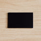 Black rectangular magnet on a beige wooden surface